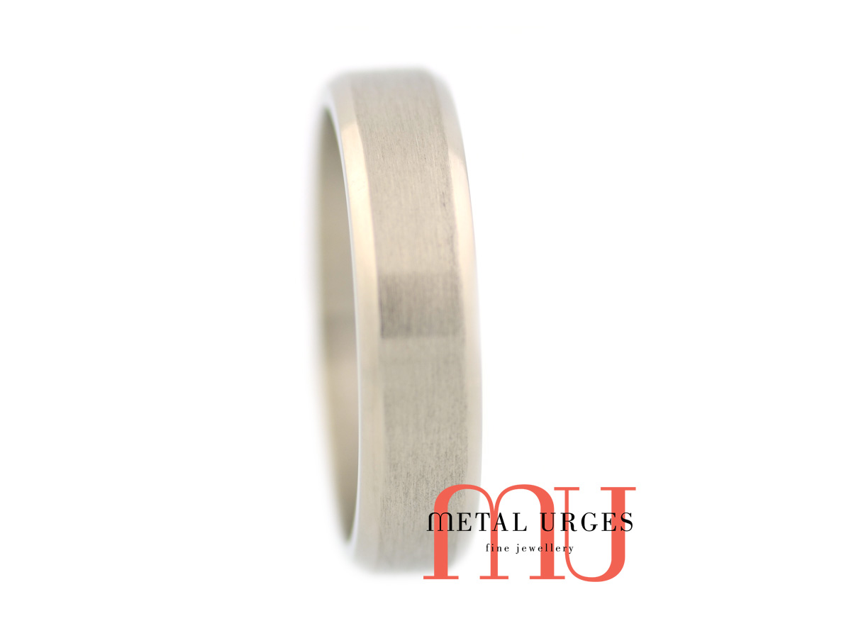 Titanium wedding ring with a central brushed rail and polished 45 degree side rails. Custom made in Australia.