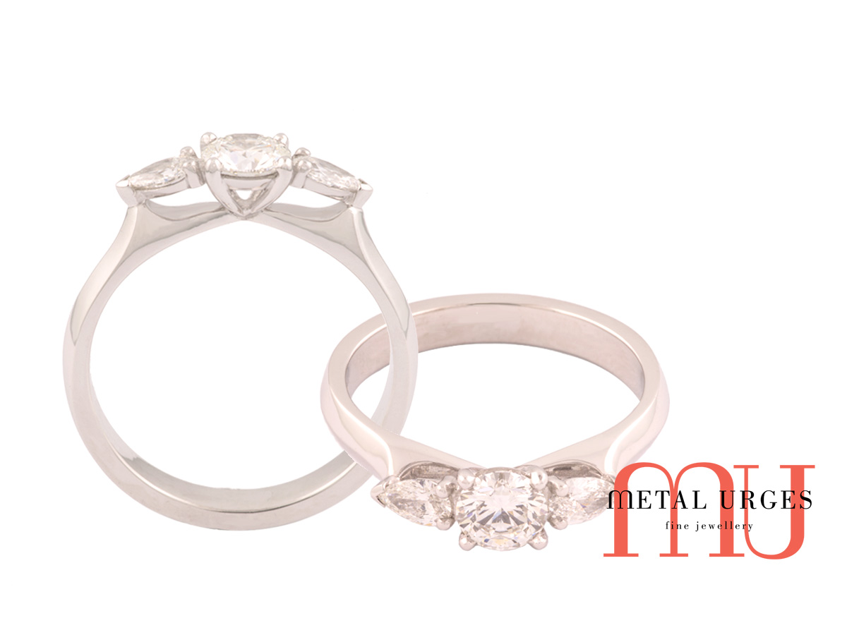 Trilogy ring of round and pear diamonds claw set in platinum.