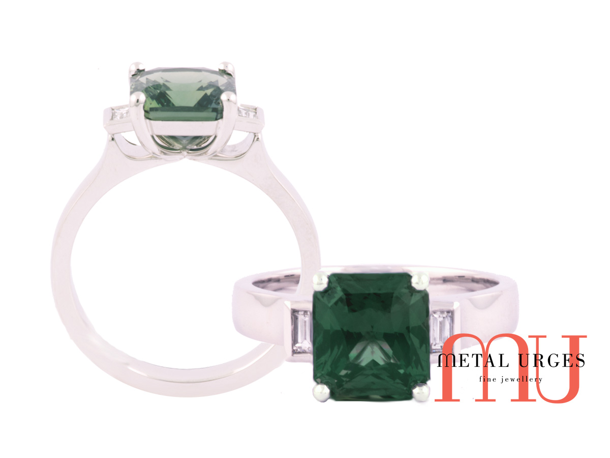 Green sapphire and baguette white diamond engagement ring in platinum