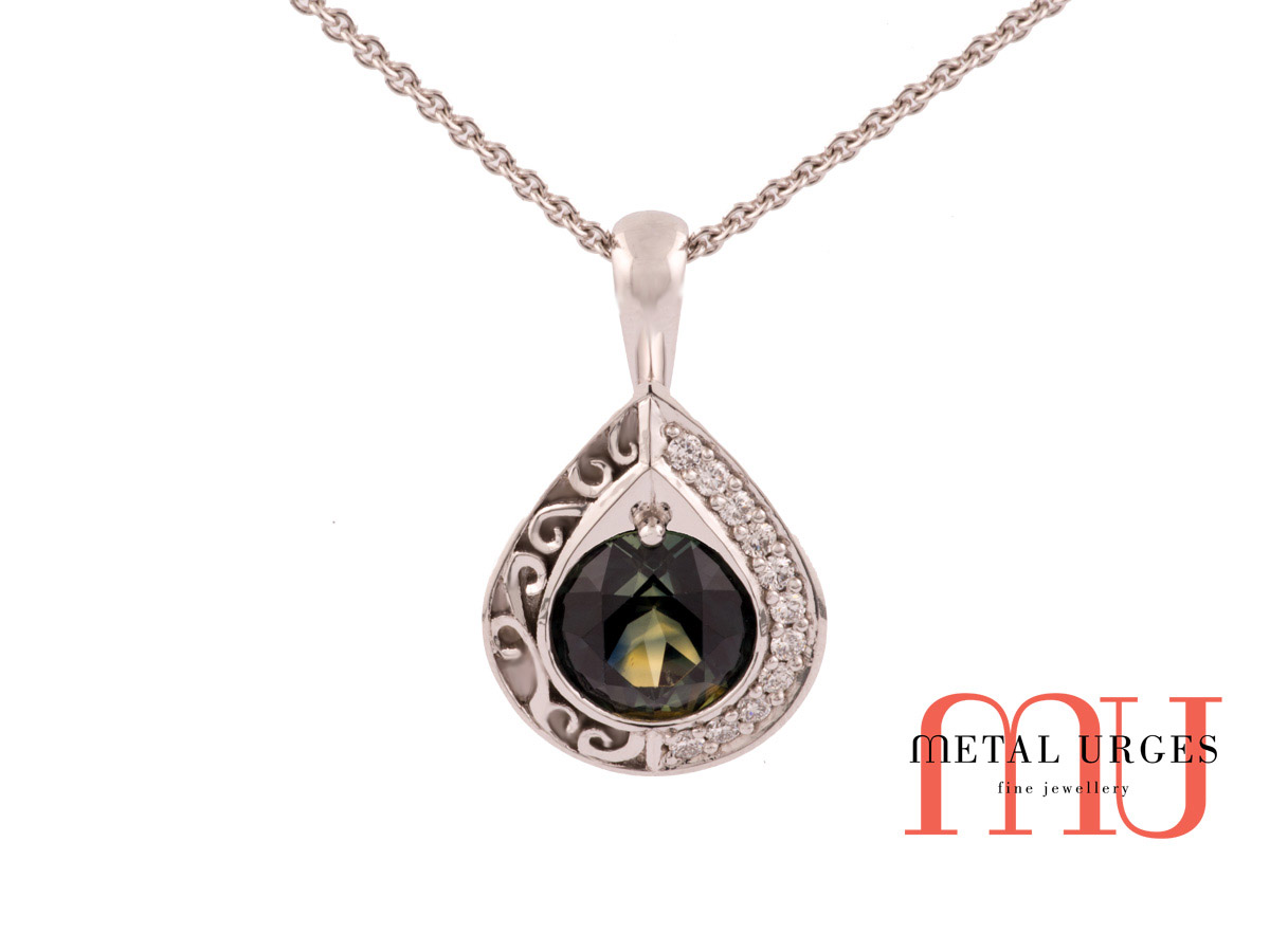 Green sapphire pendant with grain set diamonds and feature engraving