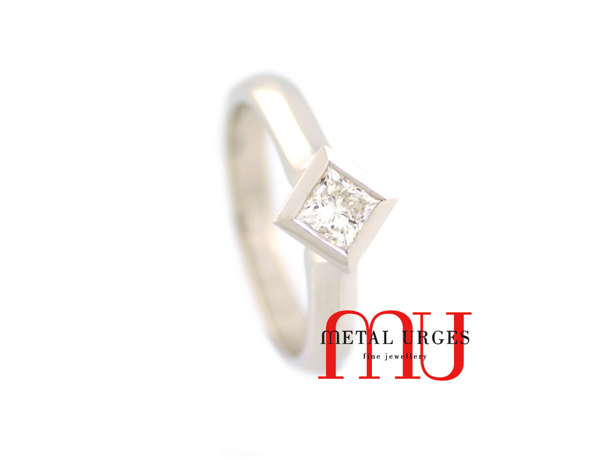 18ct white gold engagement ring, features a princess cut white diamonds bezel set on the diagonal with a fine knife edge band.  Custom made in Hobart.