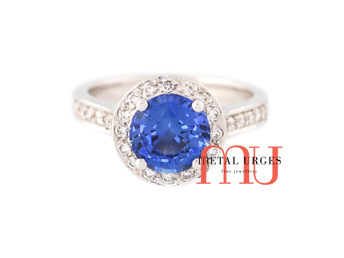 Vibrant blue sapphire and round white diamond modern cluster engagement ring in 18ct white gold. Custom made in Australia.